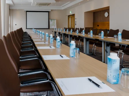 Modern conference room setup with empty chairs and tables, ready for guests.