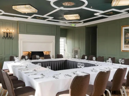 Elegant meeting room set for a conference with a U-shaped table in a stylish hotel.