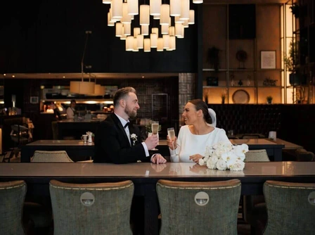 A couple enjoys drinks in an elegant hotel lounge with ambient lighting.