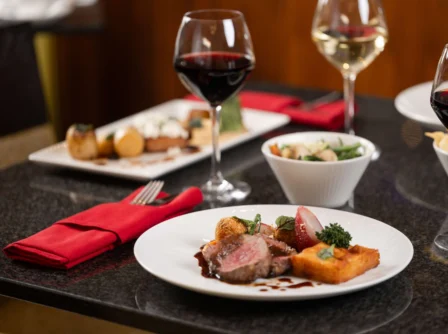 Elegant dining setting with gourmet dishes and wine, exuding warmth and luxury.