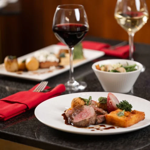 Elegant dining setting with gourmet dishes and wine, exuding warmth and luxury.