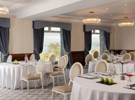 Elegant hotel conference room with round tables and lake view.