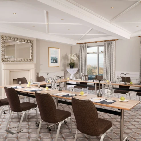 Elegant conference room with modern decor and large windows overlooking a scenic view.