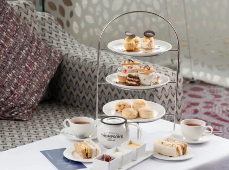 Afternoon tea setup with sandwiches, scones, and pastries in a cosy hotel lounge.