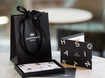 Elegant Hastings Hotels gift bag with cards on a marble table.