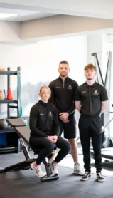 Fitness team in a modern Hastings Hotels gym, ready to assist guests with workouts.