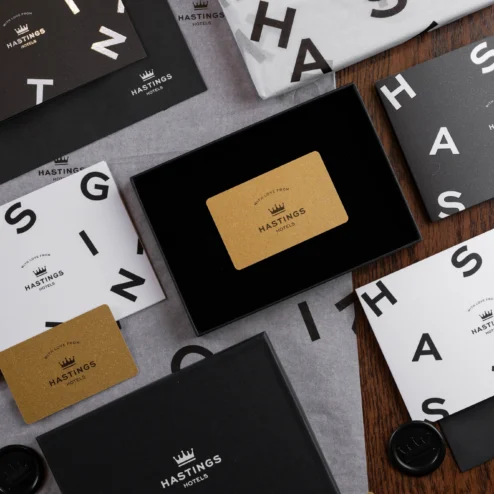 Hastings Hotels gift cards and envelopes on a wooden table.