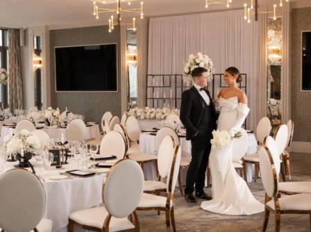 Elegant couple in formal attire at beautifully decorated wedding reception.