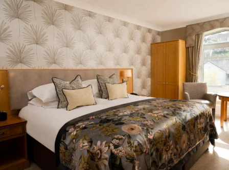 Cosy hotel room with floral decor and natural light through a large window