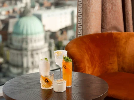 Elegant lounge with drinks, cityscape view of a domed building through the window.