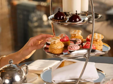Elegant afternoon tea with pastries and desserts in a hotel setting.