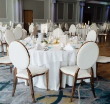 Elegant dining tables set for an event in a luxurious hotel banquet hall.