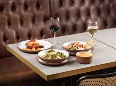Elegant table setting with gourmet dishes and wine in a cosy, upscale restaurant.