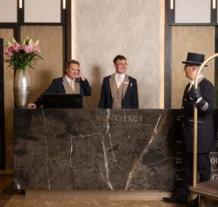 Welcoming concierge staff assisting guests at luxury hotel reception.