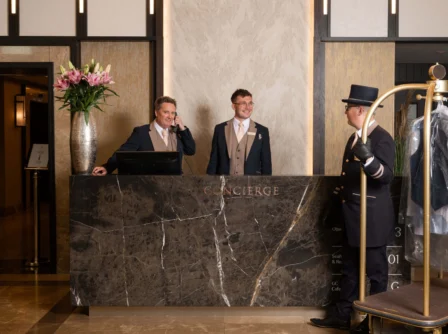 Welcoming concierge staff assisting guests at luxury hotel reception.