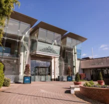 Elegant entrance to Stormont Hotel with clear blue sky and landscaped garden.
