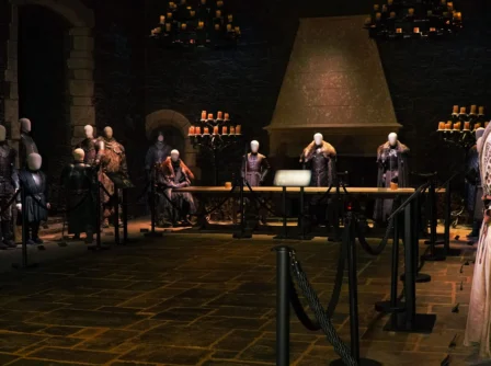 Guests exploring historical armour display in elegant, dimly-lit hotel hall.