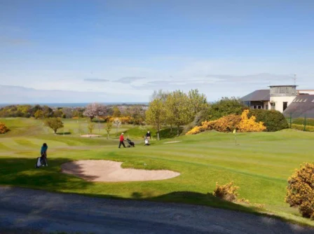 Family enjoying a sunny day golfing on a lush course at Hastings Hotels.