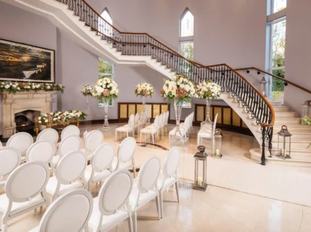 Elegant wedding venue with floral decor and grand staircase at Hastings Hotels.