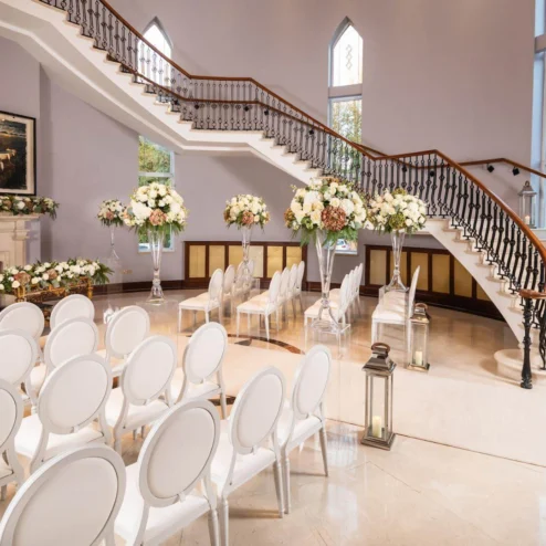 Elegant wedding venue with floral decor and grand staircase at Hastings Hotels.