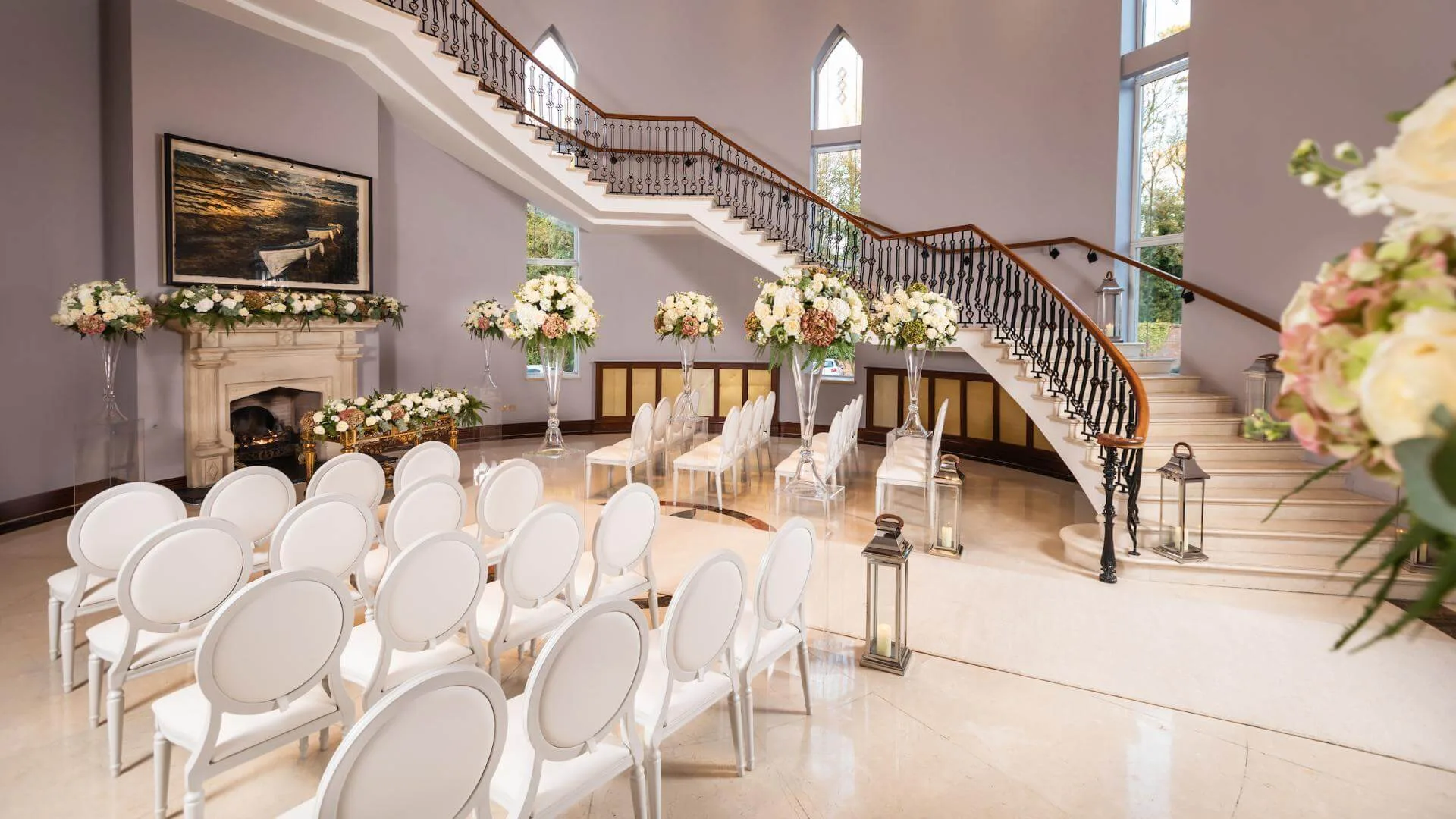 Elegant wedding venue with floral decor and grand staircase at Hastings Hotels.