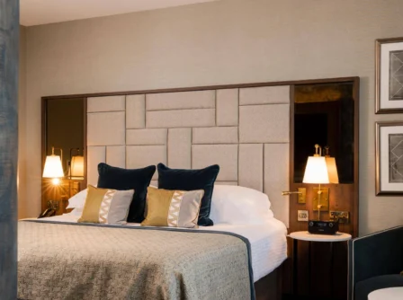 Elegant hotel room with plush pillows and soft lighting.