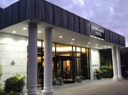 Elegantly lit entrance of Everglades Hotel in the evening with welcoming ambiance.