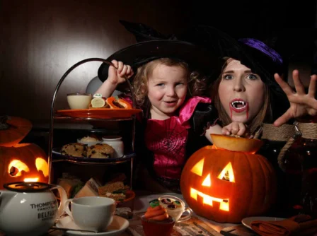Family enjoying Halloween afternoon tea with pumpkin decorations at Hastings Hotels.