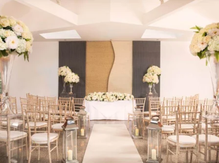 Elegant wedding venue with white flowers and decorative seating.