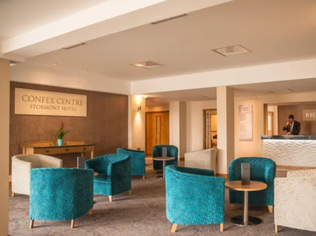 Inviting hotel lounge with cosy seating and reception desk in a warm, welcoming atmosphere.