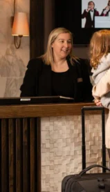 Family checking into hotel at welcoming reception desk.