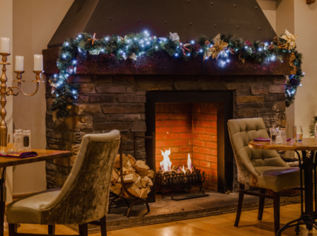 Cosy hotel lounge with decorated fireplace and elegant seating.