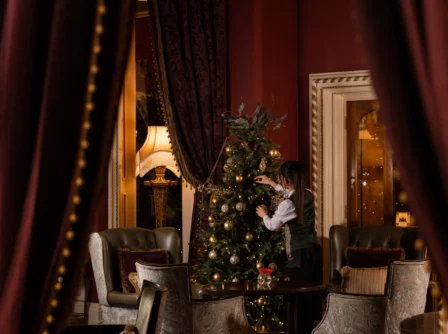 Warm hotel lounge with Christmas tree and cosy seating area.