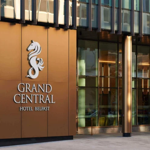 Elegant entrance of Grand Central Hotel Belfast with modern glass facade.