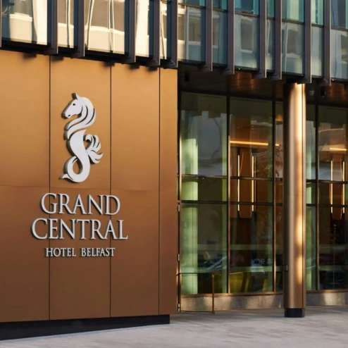 Elegant entrance of Grand Central Hotel Belfast with modern glass and bronze accents.