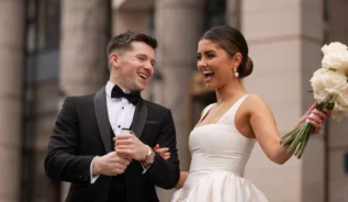 Smiling couple in formal attire outside Europa Hotel.