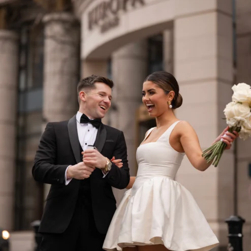 Smiling couple in formal attire outside Europa Hotel.